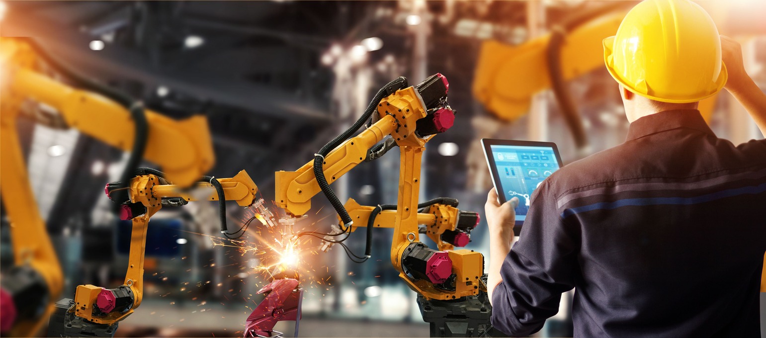 Engineer checks and controls welding 入禽太深 automatic arms machine in intelligent factory automotive industrial with monitoring system software