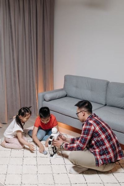 A man playing with his kids while holding the 欲望电影